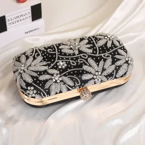 Detailed view of a black velvet beaded evening clutch with gold hardware and floral embroidery.