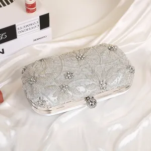 Close-up detail of silver rhinestone evening clutch bag with intricate beaded floral embroidery.