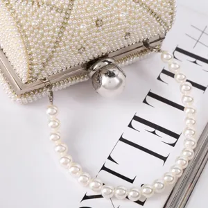 Elegant pearl mini evening bag with rhinestone details and chic pearl handle for women.