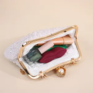 Pearl evening clutch bag detail showing interior compartment and metal frame design.