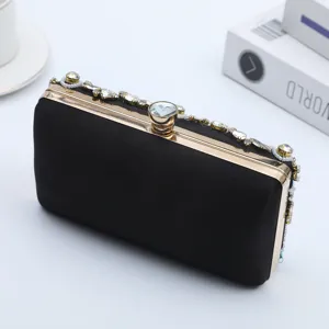 Elegant black satin clutch bag with rhinestone and pearl embellishments for evening parties.