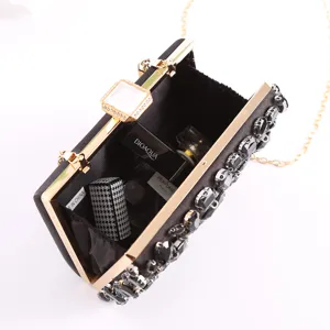 Black crystal evening clutch bag with rhinestone embellishments and gold chain strap for party.