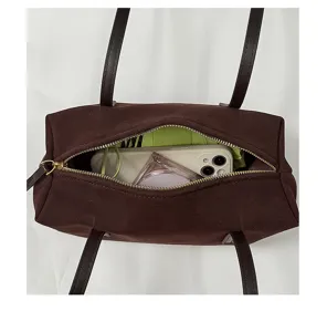 Vue détaillée de l'intérieur d'un sac à main vintage marron avec fermeture éclair et rangement.