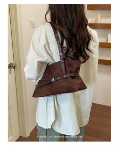 Casual vintage bruine suède schoudertas met chique metalen oogjes en gespdetails.