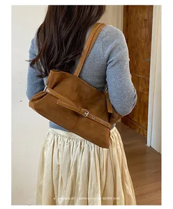 Retro bruine suède schoudertas voor dames, stijlvolle okseltas met mooie riemversiering.