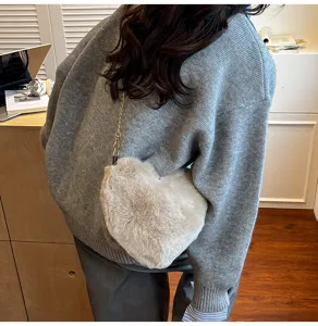 Cute fuzzy heart-shaped crossbody bag with chain strap, soft plush shoulder handbag for women.
