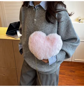 Cute fluffy pink heart-shaped crossbody bag detail showing soft plush texture and gold chain.