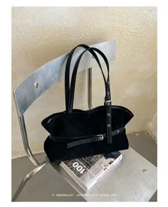 Gedetailleerd overzicht van zwarte suède schoudertas met chique riemband, retro minimalistisch.