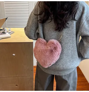 Pink plush heart crossbody bag for women, cute winter fluffy chain shoulder handbag.