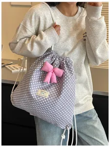 Vue rapprochée du sac à dos cordon pois doux avec nœud rose, accessoire tendance d'automne.