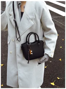 Schwarze gewebte Damen Umhängetasche Eimer Tasche mit stilvollem Perlenanhänger Detail.