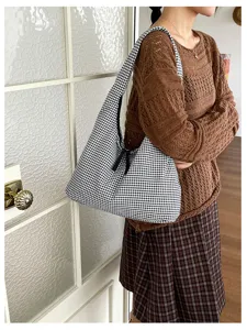 Detailed view of casual black and white gingham shoulder bag, slouchy daily hobo handbag style.