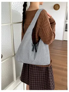 Detailed view of the black and white gingham slouchy shoulder bag showcasing fabric texture.