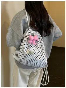 Vue détaillée en gros plan d'un joli sac à dos à pois avec un nœud rose et une étiquette.