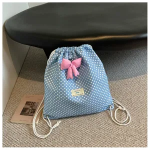 Sac à dos cordon à pois bleus avec nœud rose, design mignon et tendance pour style quotidien.