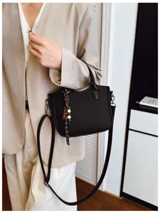 Detailansicht der eleganten schwarzen Webmuster-Eimer Tasche mit feiner Verarbeitung und Riemen.