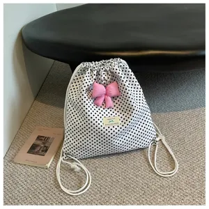 Vue détaillée du sac à dos à cordon blanc à pois avec joli nœud rose et style.