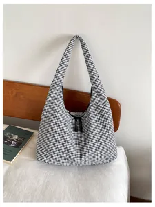 Detail close-up view of the black and white plaid canvas shoulder bag, casual daily style.