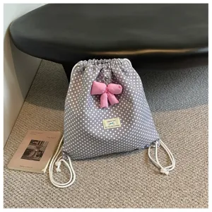 Sac à dos cordon gris à pois chic avec joli nœud rose, style décontracté doux pour usage quotidien.