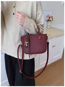 Nahaufnahme der Damen Retro Webtextur Umhängetasche Eimer Tasche mit Perlenanhänger.
