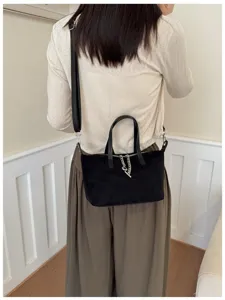 Schwarze Wildleder Umhängetasche Detail, schicke minimalistische Tasche mit Kette.