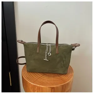 Olivgrüne Wildleder Umhängetasche mit braunem Griff und silberner Kette für Damen.