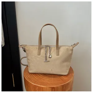 Detailansicht der minimalistischen khakifarbenen Wildleder Handtasche mit Silberkette.