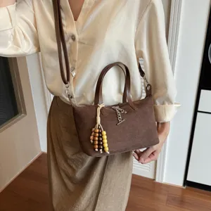 Braune Wildleder Umhängetasche für Damen mit Perlenanhänger und Kettendetail.