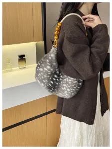 Détail de sac sous les aisselles en peluche douce avec poignée de perles en bois.