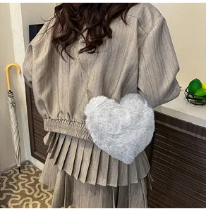 Fluffy plush heart-shaped crossbody bag for women, cute winter shoulder handbag with chain.