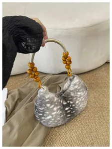 Vue détaillée du sac sous les aisselles en peluche rétro avec poignée en perles de bois.