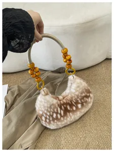 Détail de sac sous les bras en fausse fourrure avec texture faon et poignée en perles de bois.