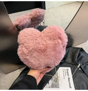 Fluffy pink heart shoulder bag detail shot, soft plush texture with metallic chain strap.