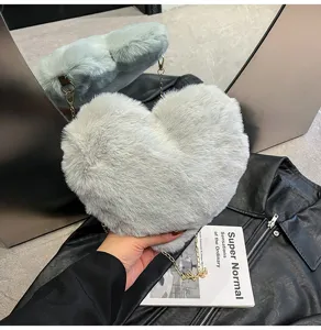 Close-up of fluffy heart-shaped crossbody shoulder bag in soft grey faux fur with chain.