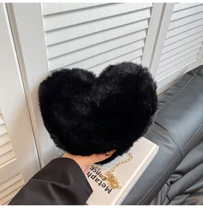Black plush heart-shaped crossbody bag with gold chain strap, chic autumn winter fashion.