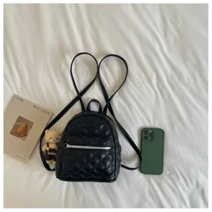 Vue détaillée de mini sac à dos matelassé noir avec motif losange classique et pièces en métal.
