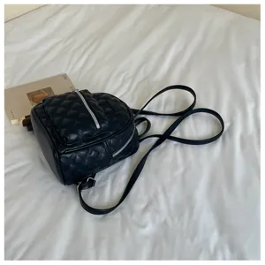 Vue détaillée d'un mini sac à dos matelassé noir tendance pour les femmes élégantes.
