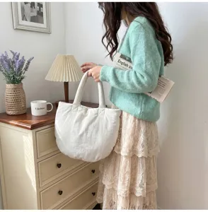 Detailansicht der weissen Wolkentasche mit weicher Textur, elegantes Accessoire fuer Alltag.