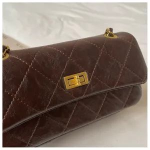 Brown quilted chain shoulder bag, elegant vintage flap bag with gold turn-lock and metallic strap.