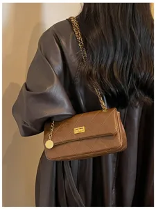 Detailed shot of brown quilted leather shoulder bag with chain strap and classic turn lock.