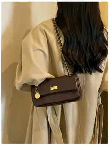 Women's quilted brown shoulder bag with gold chain strap and turn lock closure for daily use