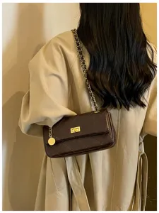 Detail view of the elegant quilted chain shoulder bag, showing refined dark brown leather texture.
