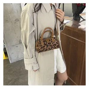 Vista detallada de un elegante bolso bandolera cilíndrico con estampado de leopardo.
