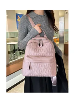 Detailed view of casual pink quilted backpack for women, stylish daily school bag with large capacity.