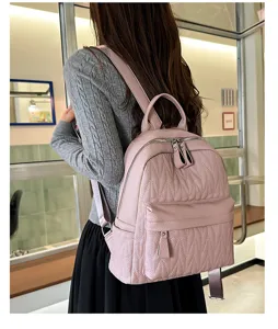 Detailed view of the stylish pink quilted leather backpack, showing vertical texture and zipper.
