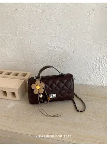 Elegante borsa a mano trapuntata marrone scuro con tracolla a catena e ciondolo fiore in paglia.