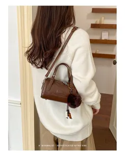 Élégant sac bandoulière Boston marron pour femme, avec pompon en fausse fourrure et perles.