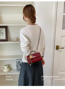 Detailansicht der roten Damen Stepptasche mit eleganter Kette und modischem Blumenanhänger.