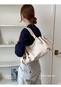 Borsa a tracolla morbida in ecopelle PU con coulisse e ciondoli con nappa eleganti.