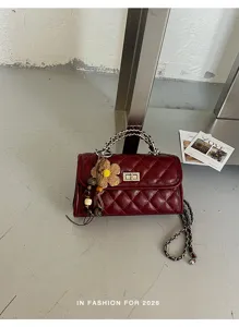 Dunkelrote gesteppte Ledertasche Detailansicht mit Kettenriemen und dekorativem Flower.